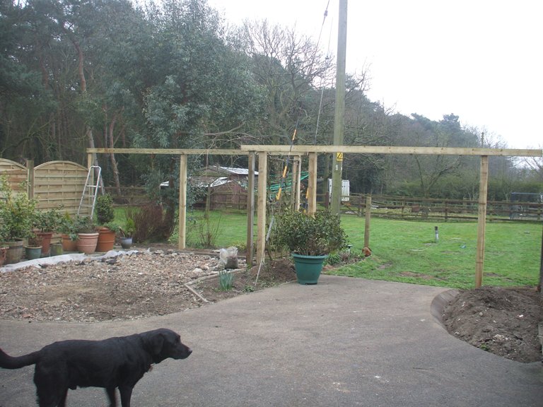 Sitting area on way to being a place for the car with framework to grow wisteria up