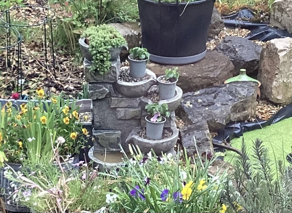 Improvised plant stand from a dead solar-powered water feature